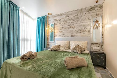 阿德耶Luxury two-bedroom apartment Four Seasons的一间卧室配有绿床和毛巾