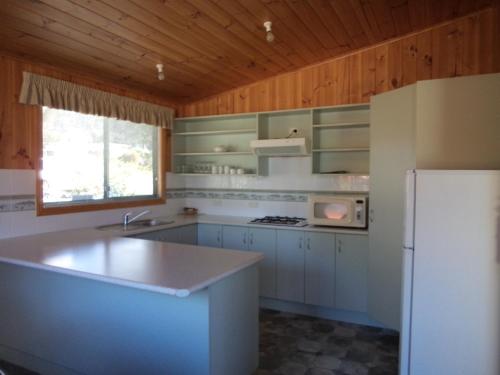 比舍诺毕奇诺东海岸假日公园酒店的厨房配有白色家电和白色冰箱