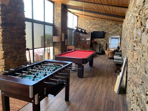 阿尔莫多瓦Monte Clérigo Casas de Campo的一间设有两张乒乓球桌和石墙的房间