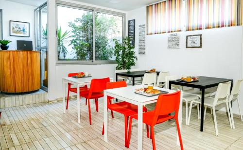 卡萨布兰卡曼济勒酒店的餐厅设有红色的桌椅和窗户