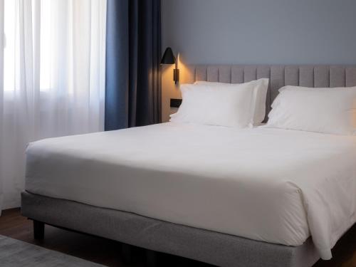莫利亚诺威尼托The Foscarini的一张配有白色床单和枕头的大床