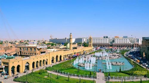 埃尔比勒Syros Hotel Erbil City Center的一座城市,在一座建筑前有喷泉