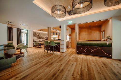 霍赫克尼希山麓丁滕萨尔茨堡霍夫酒店的客厅铺有木地板,配有绿色椅子。