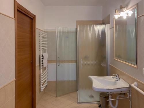 特伦托阿格里图维奈托旅馆的一间带玻璃淋浴和水槽的浴室