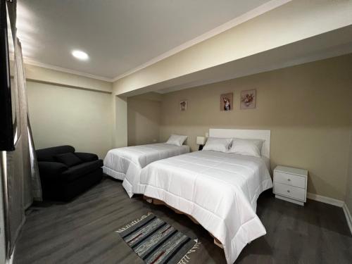 CarazDepartamentos Caraz的酒店客房,设有两张床和一张沙发