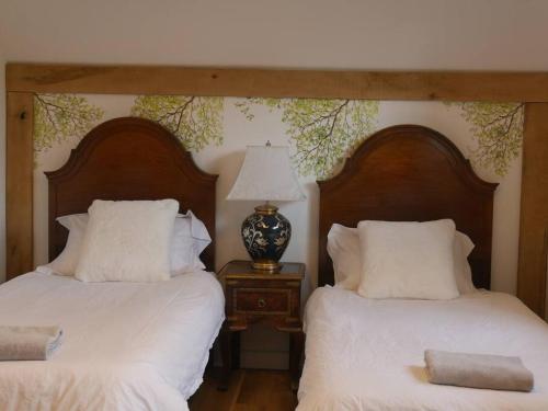 切尔滕纳姆Cheltenham accommodation -self-catering-2 bedrooms的两张带白色床单和台灯的床