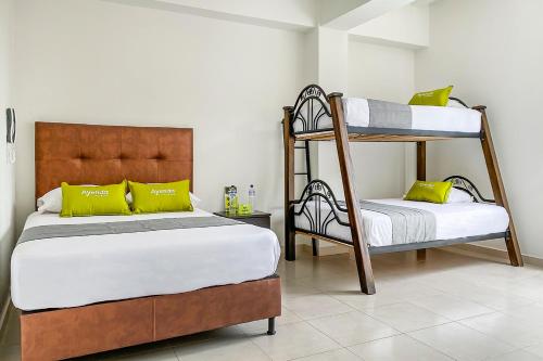 多斯克布拉达斯Ayenda 1138 Apartahotel 109的一间卧室配有两张双层床和黄色枕头。
