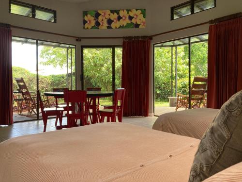 阿拉胡埃拉Villas Aracari的一间卧室配有两张床和一张桌子及椅子