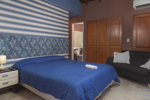 圣胡安讷沃苏左酒店的一间卧室配有蓝色的床和沙发