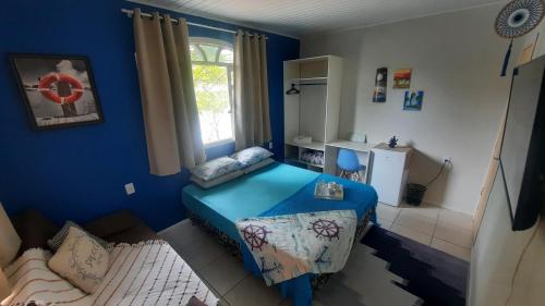 伊达贾伊Suíte Azul com SmartTv, Cama Queen e Banheiro Privativo的蓝色的客房设有床和窗户。