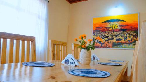 阿鲁沙Osotwa Maasai Hostel的一张带蓝色板子和花瓶的木桌