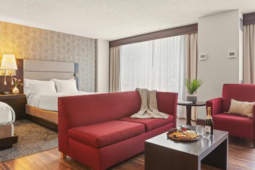 斯坦福德Armon Hotel & Conference Center Stamford CT的酒店客房配有红色的沙发和床。