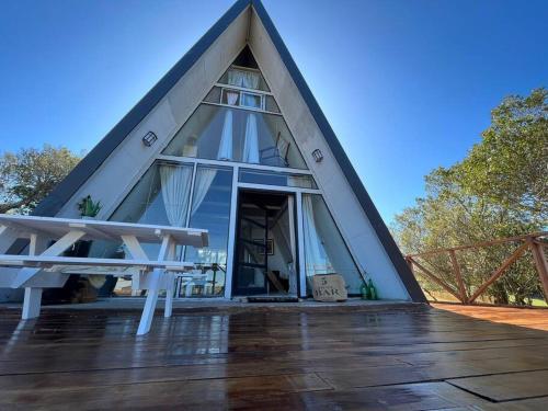 塞拉纳镇Cabaña Nórdica muy cómoda para unos días de relax的三角形房屋设有茅草屋顶和木甲板