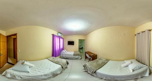 巴西利亚Pousada Jardim Brasília的一间设有两张床和一张桌子的房间