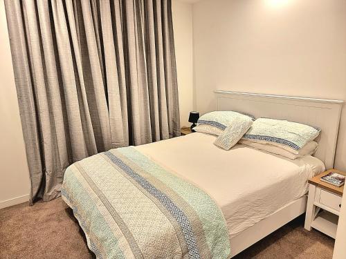 玛志洛Maroochy City Lights@Thecosmopolitan Unit 20802的一间卧室配有床和带窗帘的窗户