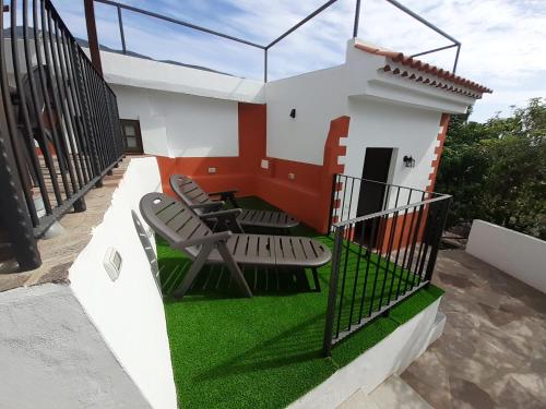AlojeraVv Puerto del Trigo - Stella的一座带椅子和草的房屋模型