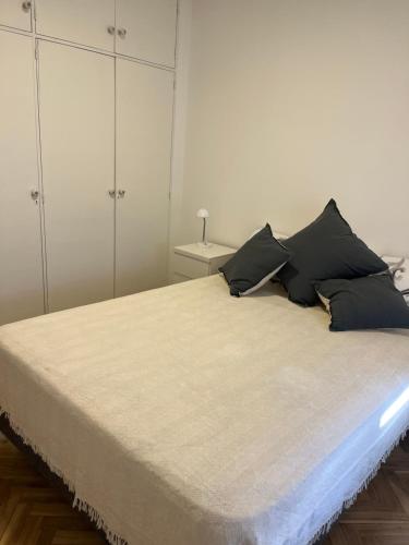 罗萨里奥Departamento luminoso en Rosario centro的一间卧室配有一张带黑色枕头的大床