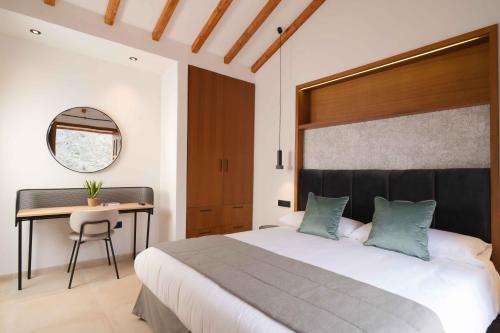 埃尔米瓜BASÂLTO Casas Rurales的一间卧室配有一张大床和一张书桌