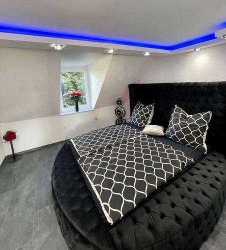 多特蒙德Phöenixpalace Whirlpool & Infarotsauna的一间卧室配有一张大床和一张黑色床架