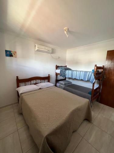 马拉戈日Casa em Peroba/Maragogi的一间卧室配有两张床和风扇
