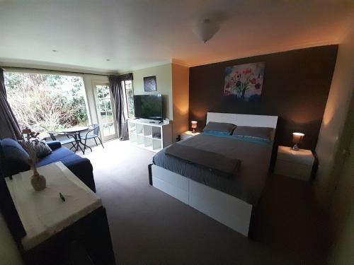 新普利茅斯Georges BnB Nature and Lifestyle Retreat的一间卧室设有一张床和一间客厅。