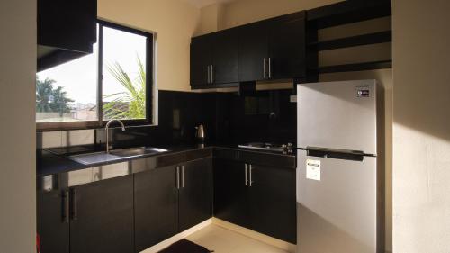 达沃市Garden Vista Hotel的厨房配有黑色橱柜和冰箱。