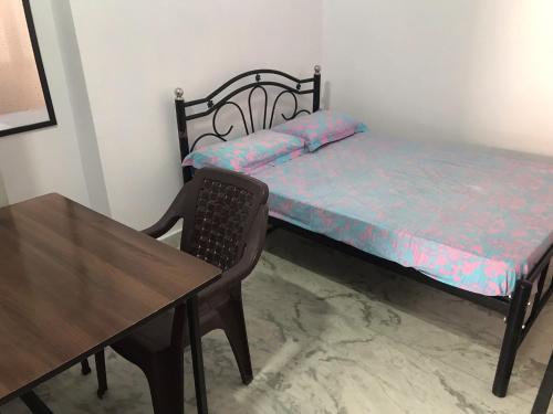 德拉敦Welcome Hostel的一间小卧室,配有一张床和一张桌子