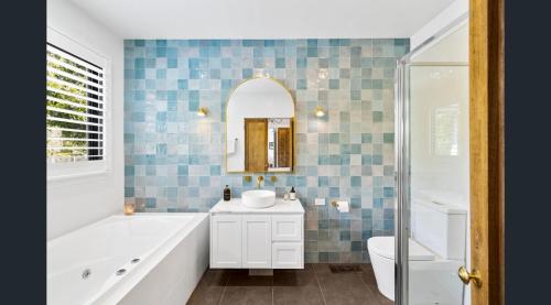 戴尔斯福特Daylesford Lake Garden Villas的带浴缸、水槽和镜子的浴室