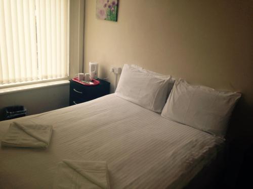 布莱克浦Peek-a-Booze - Budget Hotel - Adults Only的一间卧室配有带白色床单和枕头的床。