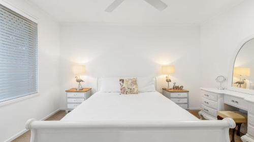 黄金海岸Coastal House的白色卧室配有床和镜子