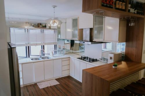 哥打京那巴鲁Petronella Apartment C1 Marina Court的厨房配有白色橱柜和木制台面