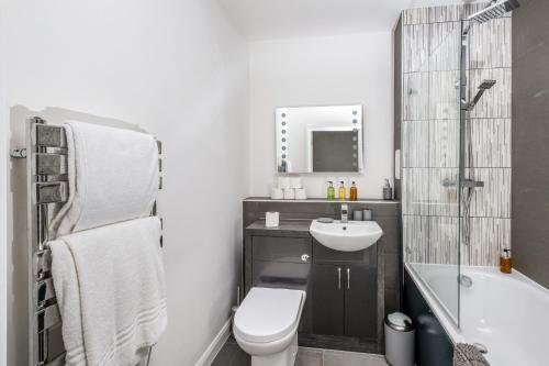 SurbitonTown Center 2 bed Serviced Apartment 08 with parking, Surbiton By 360Stays的浴室配有盥洗盆、卫生间和浴缸。