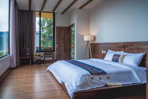 萨帕Sapa Pine Hill Eco Lodge的一间卧室配有一张大床和木制床头板