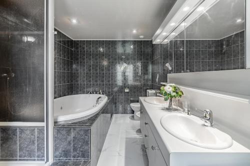 TerritetBon-Port Luxury apartment - Lakefront的一间带两个盥洗盆、浴缸和卫生间的浴室