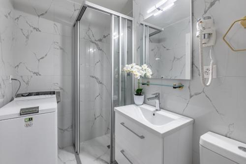 TerritetGarden of Eden 1-bedroom apartment – Lakefront的白色的浴室设有水槽和淋浴。
