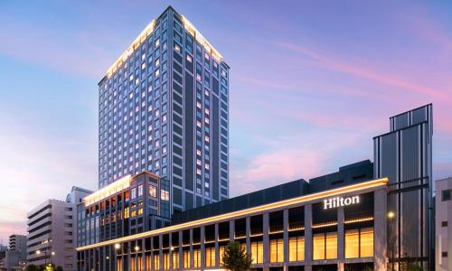 广岛Hilton Hiroshima的一座高大的建筑,有很多窗户