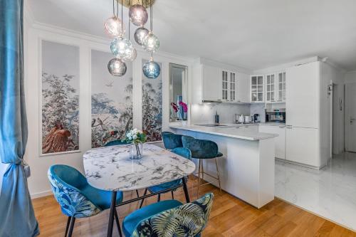 TerritetSoft Glam 1-bedroom appt - Lake & Mountain View的一间厨房,内设一张桌子和蓝色的椅子