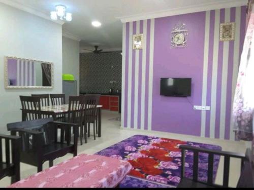 Kampong Alor GajahNor Su Homestay的一间设有一张桌子和紫色墙壁的用餐室