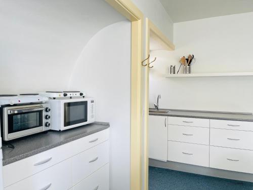 腓特烈港aday - Frederikshavn City Center - Charming double room的厨房配有白色橱柜和微波炉