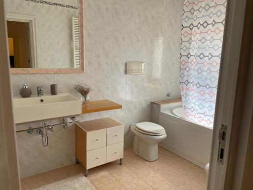布林迪西Parvis home的浴室配有盥洗盆、卫生间和浴缸。