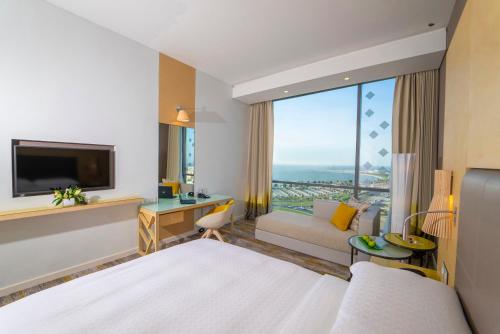 达曼Dana Rayhaan by Rotana的酒店客房配有床、沙发和电视。