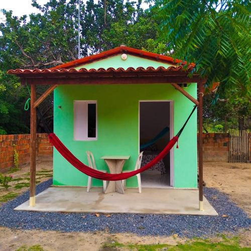 CruzMila chalé的一座绿色的小房子,周围是红绳