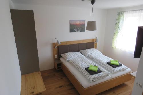 Gasthof Schmidt的一间卧室配有一张带两个绿色枕头的床