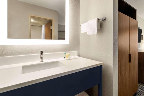 布兰森AmericInn by Wyndham Branson & Conference Center的浴室设有白色水槽和镜子