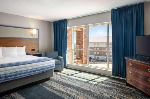 布兰森AmericInn by Wyndham Branson & Conference Center的酒店客房设有一张床和一个大窗户