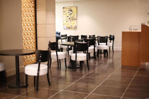 延布拉哈尔套房酒店的用餐室配有黑桌和白色椅子