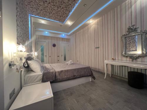 巴库Megafun Luxury Family Apartment的一间卧室配有床、镜子和水槽