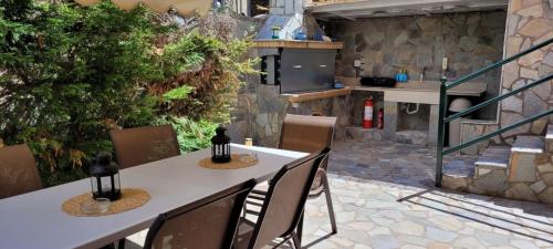 纳弗帕克托斯cozy apartment nafpaktos的一个带桌椅的庭院和一间厨房