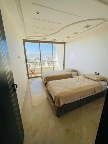 阿加迪尔Very nice apartment near the city center & beach的带大窗户的客房内的两张床