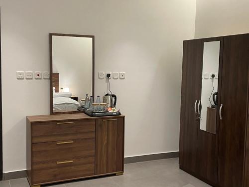 欧拉LADAN APARTMENT的一间卧室配有木制梳妆台和镜子